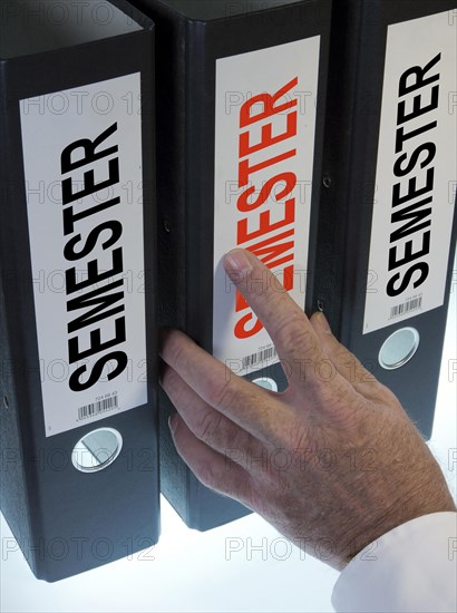 Hand reaching for a file folder labeled 'Semester'