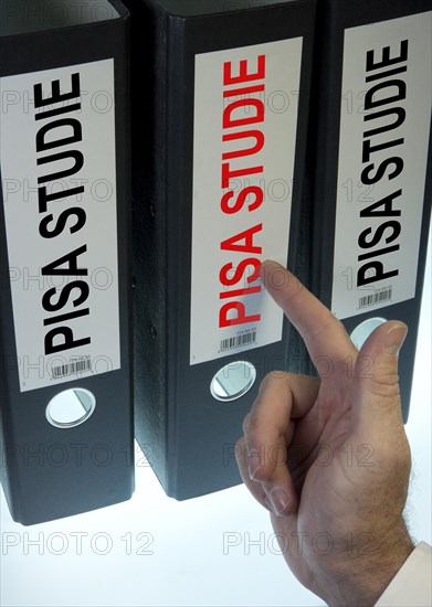 Hand pointing to a file folder labeled 'PISA-Studie'