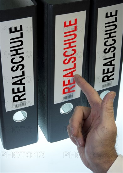 Hand pointing to a file folder labeled 'Realschule'