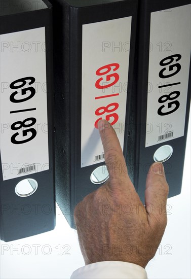 Hand pointing to a file folder labeled 'G8 - G9'