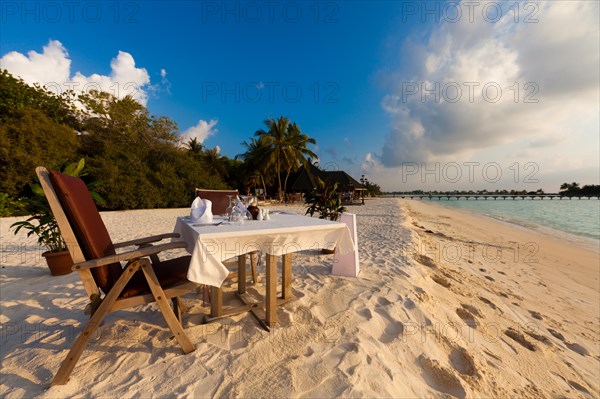 A table laid for dinner standing on the beach