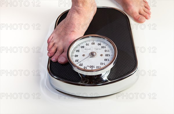 A man stepping on bathroom scales