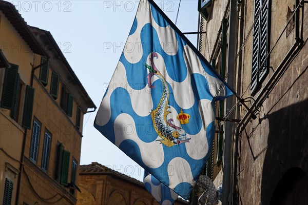 Flag of a contrada district in an alley of the historic town centre