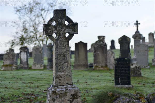 Old Scottish graveyard with Celtic crosses and gravestones with hoarfrost-covered grass