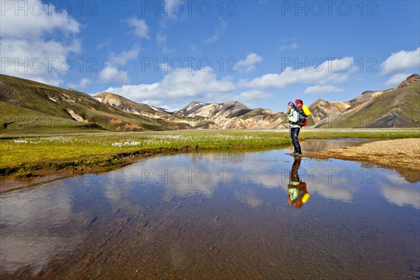 Reflection of a young woman in a pond