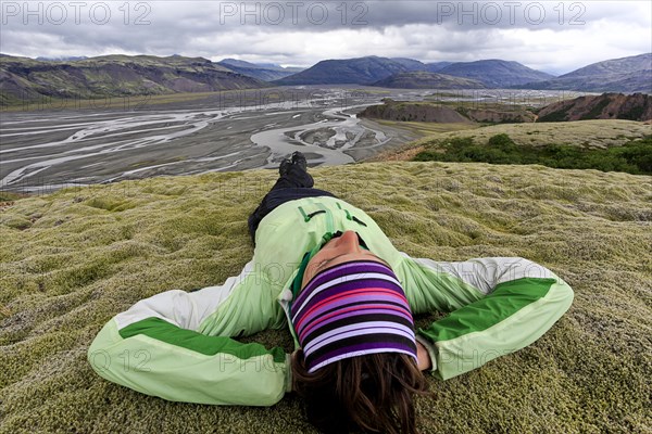 Young woman lying in a moss landscape