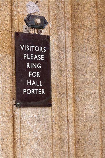 Visitors please ring for hall porter' sign by door bell button