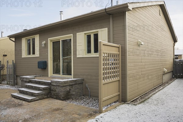 Rear view of a Residential bungalow and backyard in winter