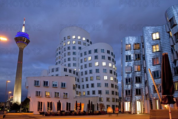 A building by American architect Frank O. Gehry and the Rheinturm tower at night