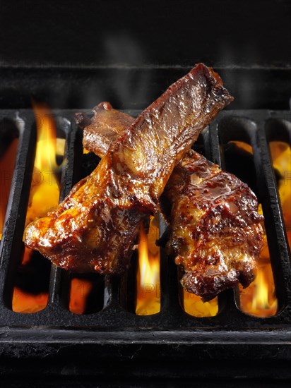 BBQ spare ribs being cooked over open flames