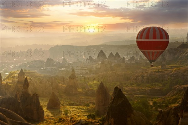 Hot air balloon over volcanic tuff rock formations at dawn