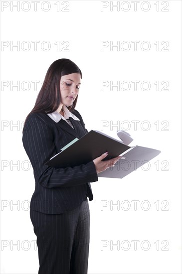 Businesswoman reading and leafing through documents in a folder