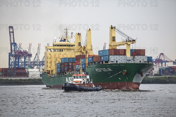 Tug boat towing a container ship on the Elbe