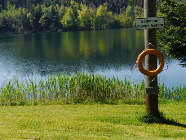 Lifebuoy and sign 'Baden auf eigene Gefahr'