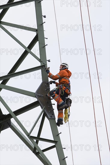 Lineman working with a wire rope hoist on a 380-kV long-distance line owned by the 50Hertz transmission system operator