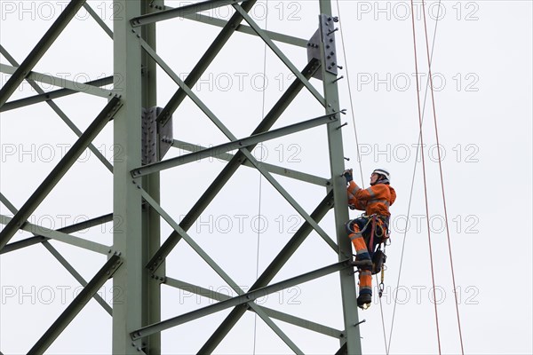 Lineman working with a wire rope hoist on a 380-kV long-distance line owned by the 50Hertz transmission system operator