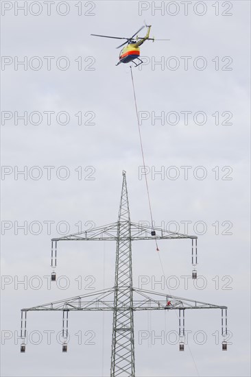 Lineman working with a wire rope hoist on a 380-kV long-distance line owned by the 50Hertz transmission system operator