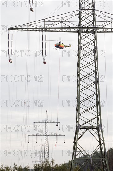 Lineman working with a wire rope hoist on a 380-kV long-distance line owned by the 50Hertz transmission system operator