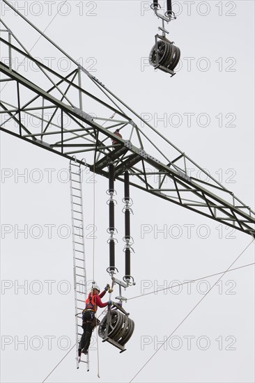 Lineman working with a wire rope hoist on a 380-kV long-distance line owned by the 50Hertz transmission system operator