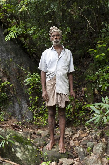 Barefoot villager standing in the jungle