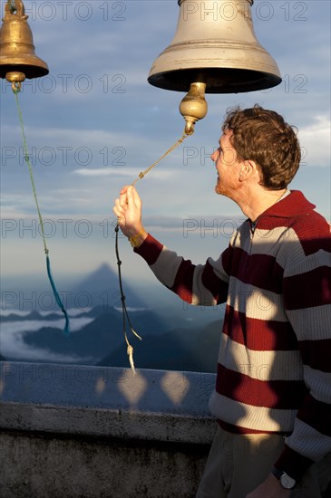 Man ringing a bell at a Buddhist temple