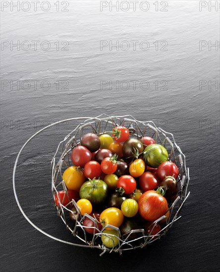 Various wild tomatoes in a wire basket