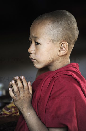 Buddhist novice praying in a monastery