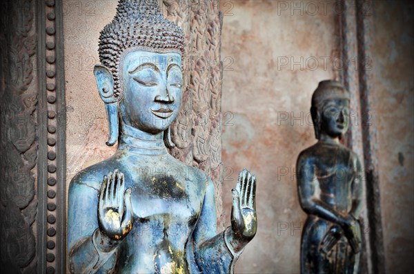 Old Buddha in front of a temple in Vientiane