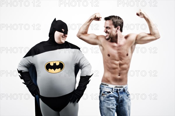 Overweight superhero laughing at a young muscular man