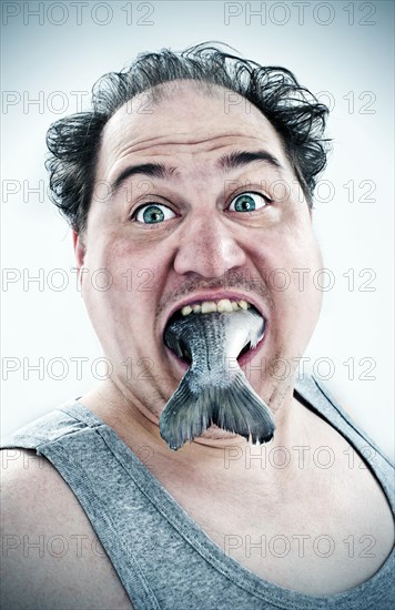 Chubby man with a fish in his mouth