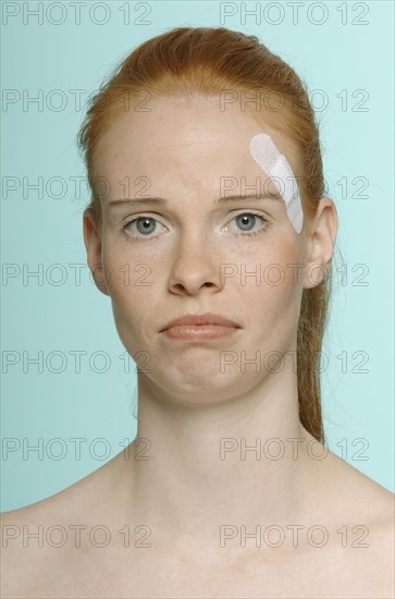 Young red-haired woman with a plaster