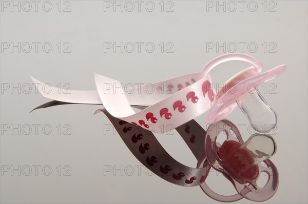 Pink pacifier on a ribbon with a duck motif
