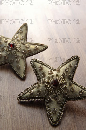 Golden textile stars on a wooden surface