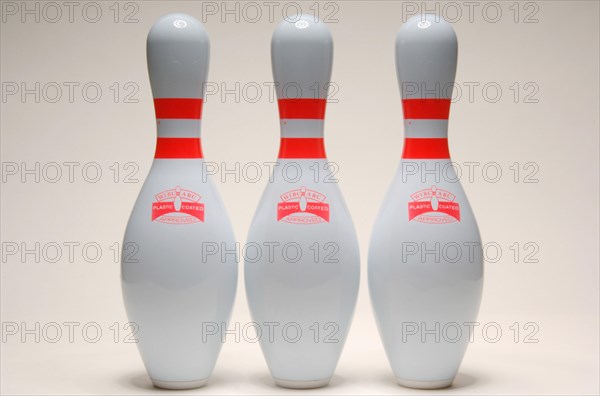 Three bowling pins lined up together