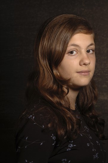 Tennage girl with long hair wearing a brown blouse