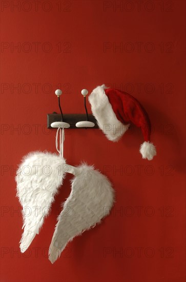 Santa hat and angel wings hanging on nostalgic coat hooks