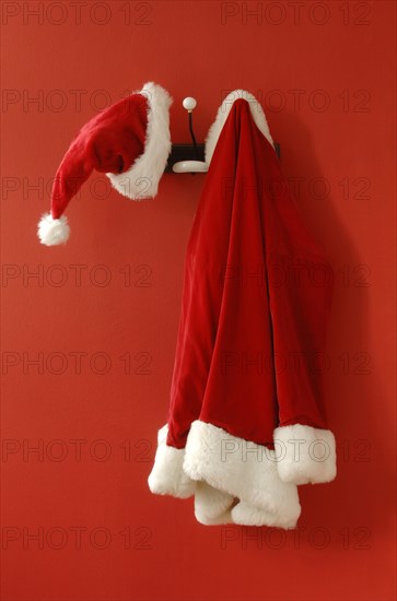 Santa Claus hat and coat hanging on nostalgic coat hooks