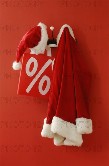 Santa Claus hat and coat with a shopping bag hanging on nostalgic coat hooks