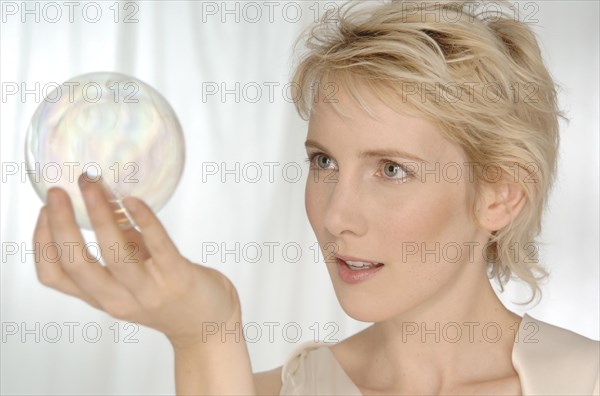 Blonde woman holding a glass sphere