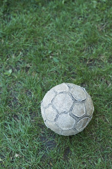 Old football lying on a lawn