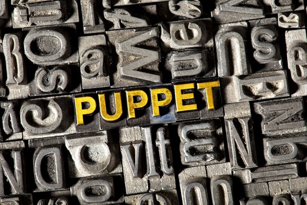 Old lead letters forming the word "PUPPET"