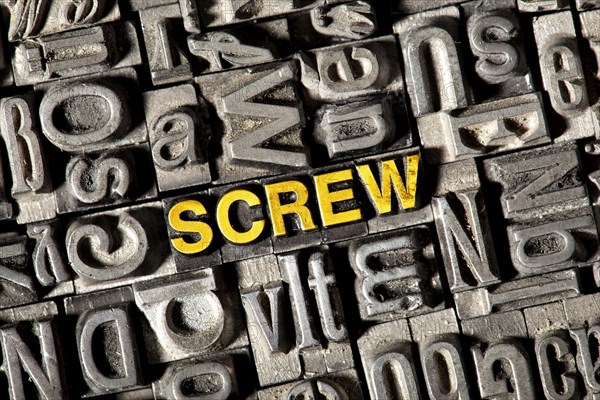 Old lead letters forming the word 'SCREW'