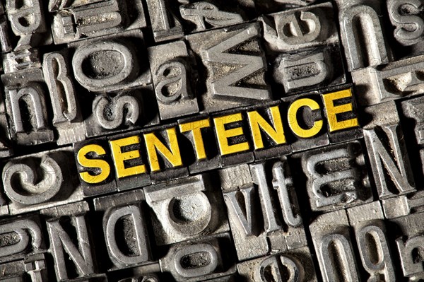 Old lead letters forming the word 'SENTENCE'
