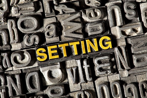 Old lead letters forming the word 'SETTING'