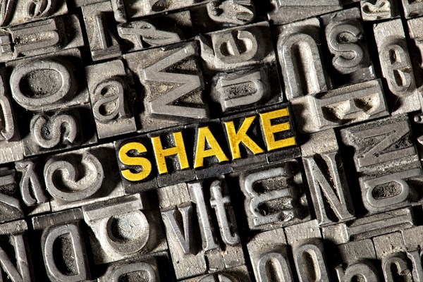 Old lead letters forming the word 'SHAKE'