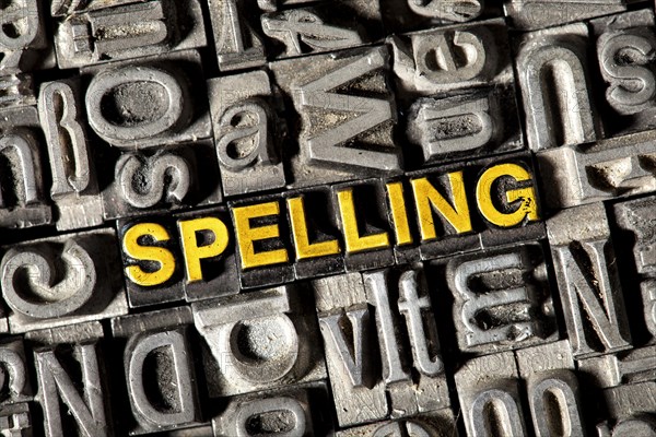 Old lead letters forming the word 'SPELLING'