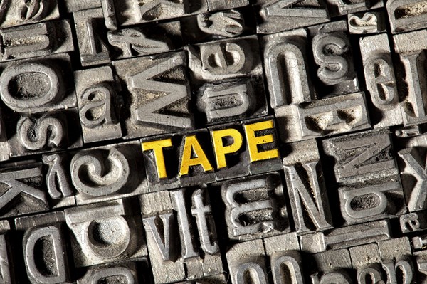 Old lead letters forming the word 'TAPE'