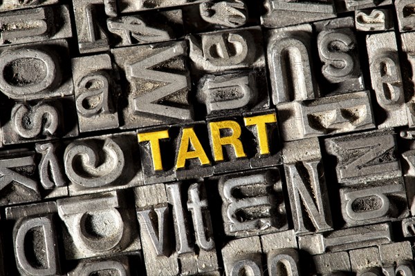 Old lead letters forming the word 'TART'