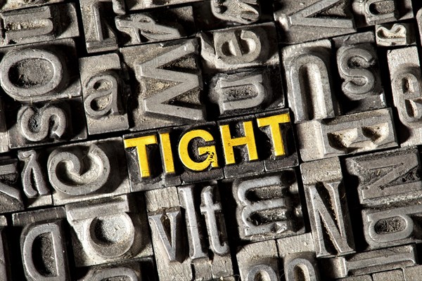 Old lead letters forming the word 'TIGHT'