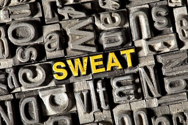 Old lead letters forming the word 'SWEAT'